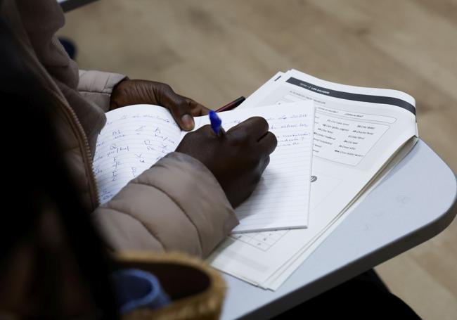 Constancia. Una de las mujeres acogidas resuelve los ejercicios propuestos por el profesor en el aula.