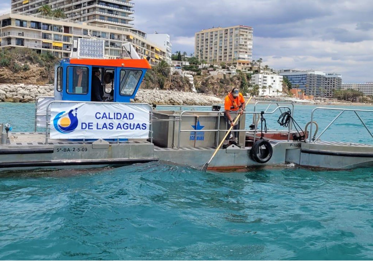 Uno de los barcos encargados de la limpieza de las aguas, frente a El Morro de Torremolinos.