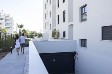 Dos inquilinos caminan por las zonas comunes de la urbanización Azahar, en Torremolinos.