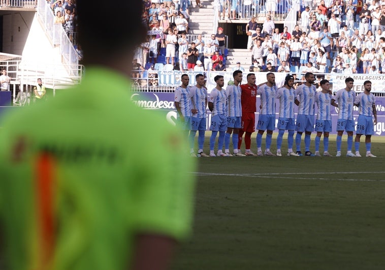 Los jugadores del Málaga, durante el minuto de silencio por la muerte de Fernando Puche.