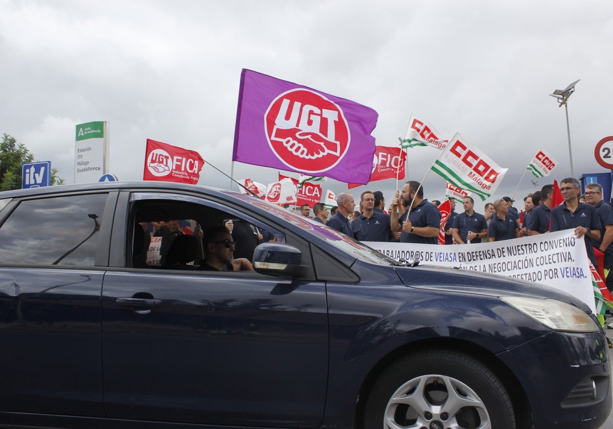 Un usuario espera a poder acceder al recinto de la ITV del polígono Guadalhorce de Málaga, en cuya entrada se concentraban empleados de las inspecciones técnicas de vehículos de la provincia.