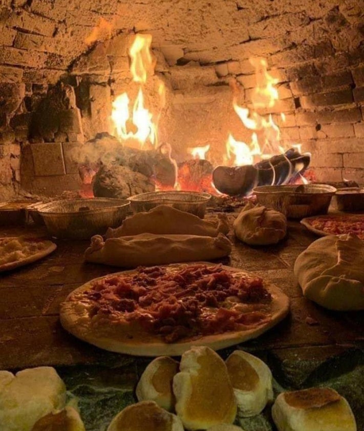 Imagen secundaria 2 - Arriba, la terraza del establecimiento; abajo a la izquierda, el mítico globo que estuvo en el tejado en los noventa, y a la derecha, pizzas y panes, listos en el horno de leña.