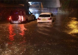 Coches atrapados en el agua esta noche en el acceso de Puerto Banús.