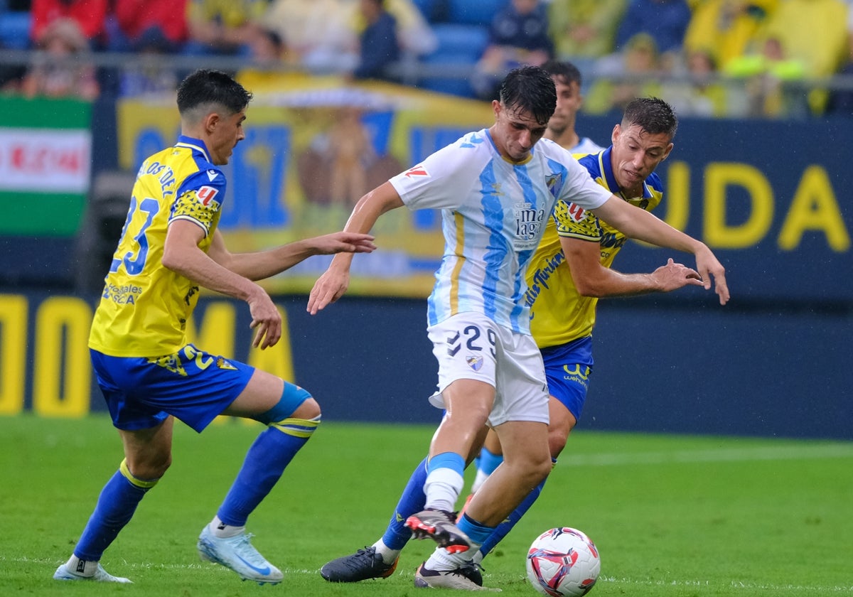 Izan Merino protege el balón ante Alcaraz y Carlos Fernández.