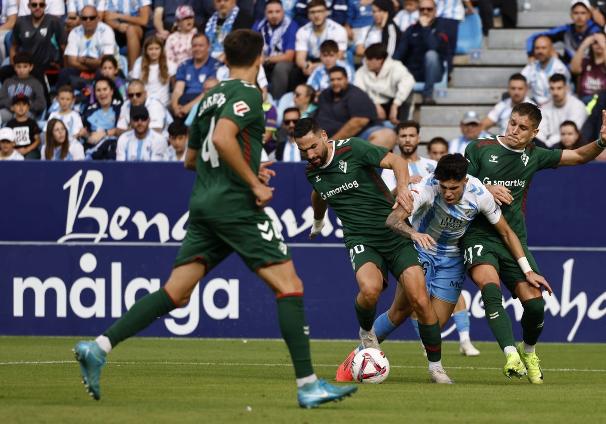 Antoñito trata de penetrar ante la vigilancia de dos rivales.