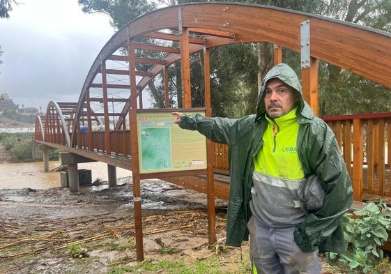 Un trabajador de Álora señala el punto por donde se desbordó el río.