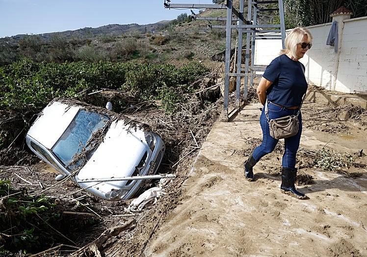 Ana Postigo junto al coche de su marido afectado por el temporal.