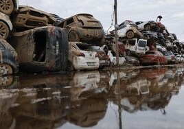 Varios coches, que fueron arrastrados por el agua tras el paso de la dana, almacenados en un descampado en Paiporta.