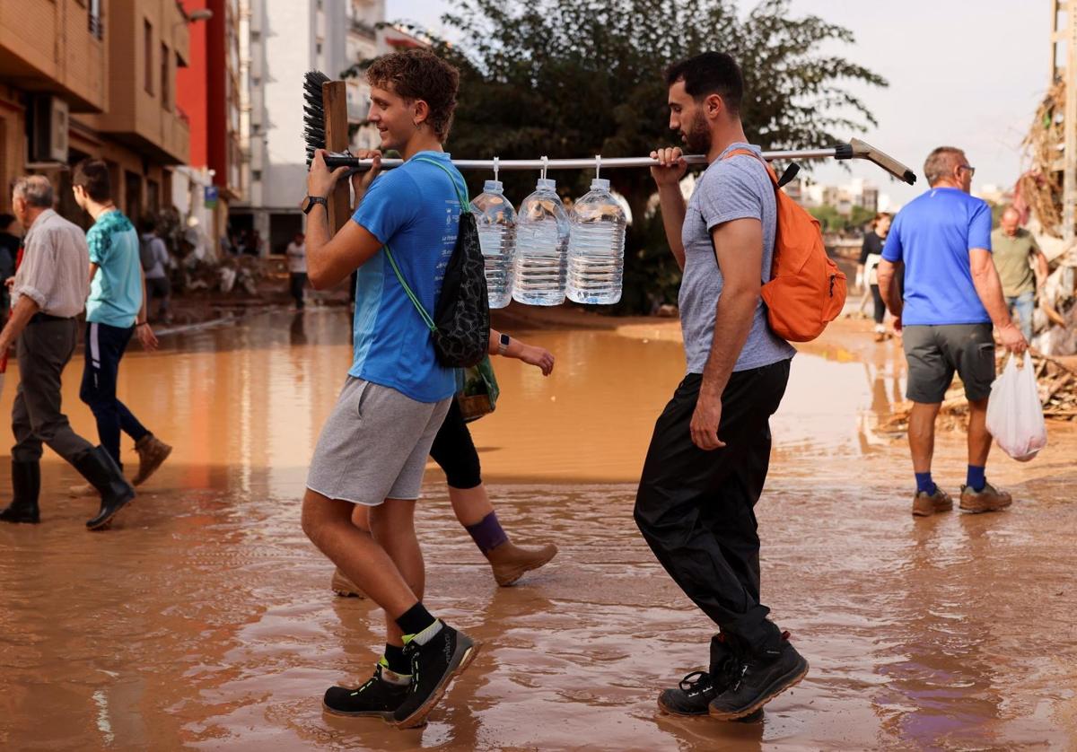 Voluntarios transportan agua en Paiporta, Valencia