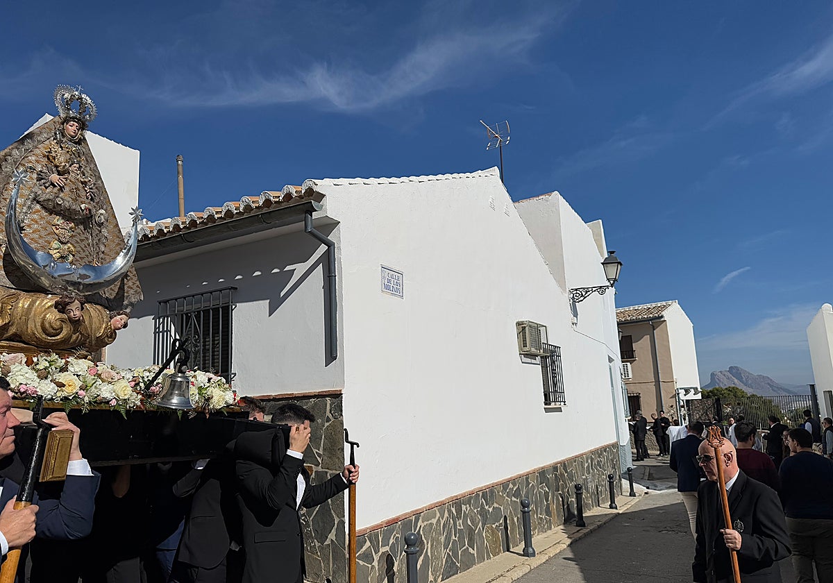 Una procesión que pasa por estrechas calles del barrio de Santiago