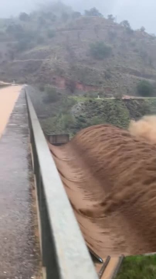 Torrente desbordado por encima de la berma de la presa de derivación del Mazmúllar en Comares, en el cauce del río Solano.