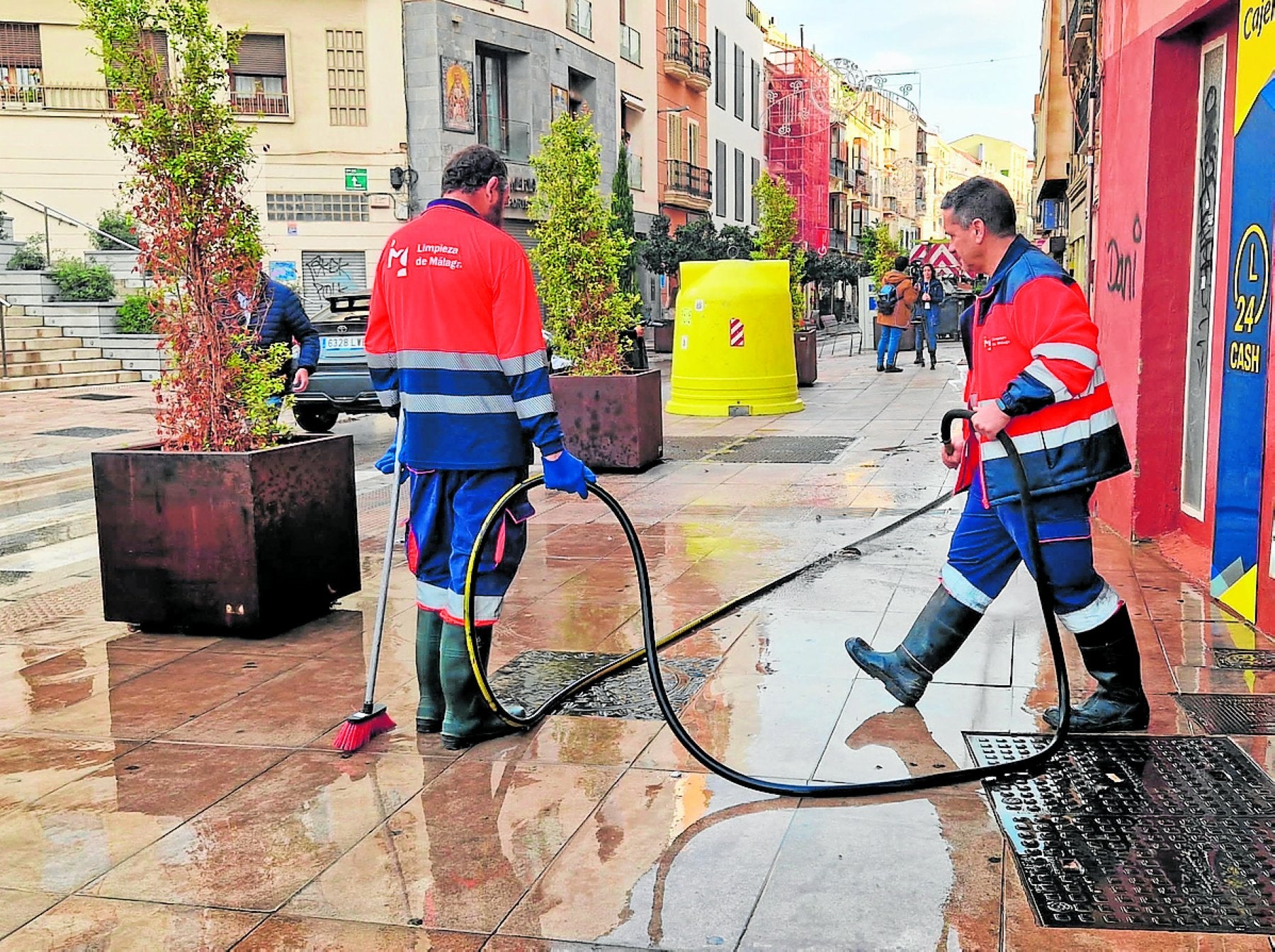 Operarios en labores de limpieza en calle Carretería el día después de la DANA.