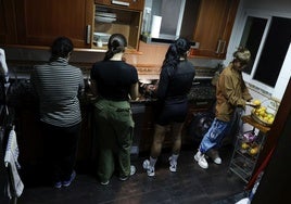 Residentes en la casa de Betania con las trabajadoras sociales, en la cocina, preparando la cena: las labores se reparten para que haya buena convivencia.