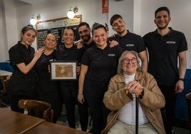 Empleados del bar Los Pueblos muestran la licencia de apertura del local de 1955. Sentado, Lucio Romero, cliente habitual.