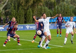 Carrasco, defensa del Marbella, choca con un futbolista del Yeclano.