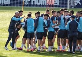 El pasillo de collejas de los jugadores y de Sergio Pellicer ayer a Puga, en su 24 cumpleaños, antes de la sesión de entrenamiento de este martes del equipo en La Rosaleda.