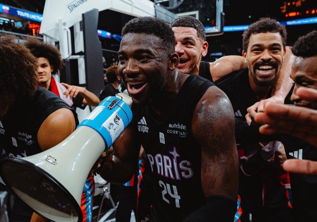 Los jugadores del París Basketball celebran una victoria con sus aficionados.