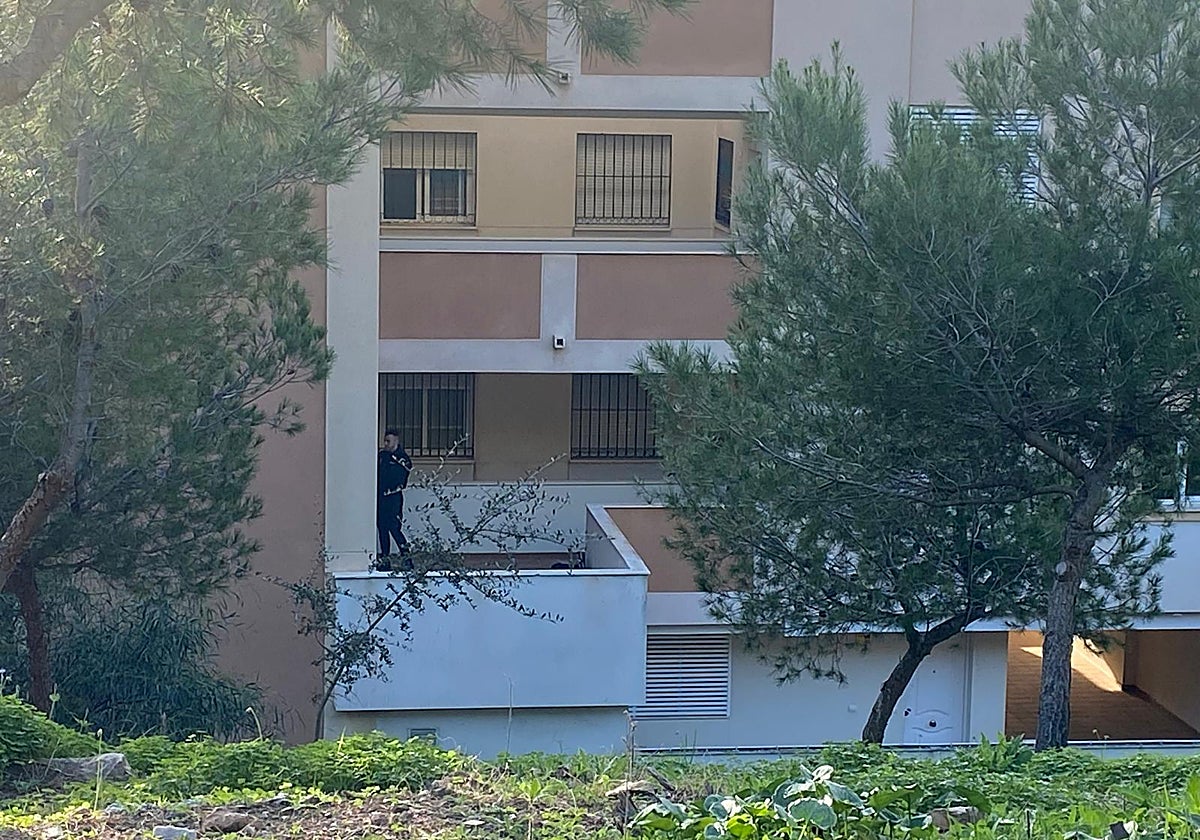 Un agente inspecciona un rellano junto a la vivienda de la víctima.