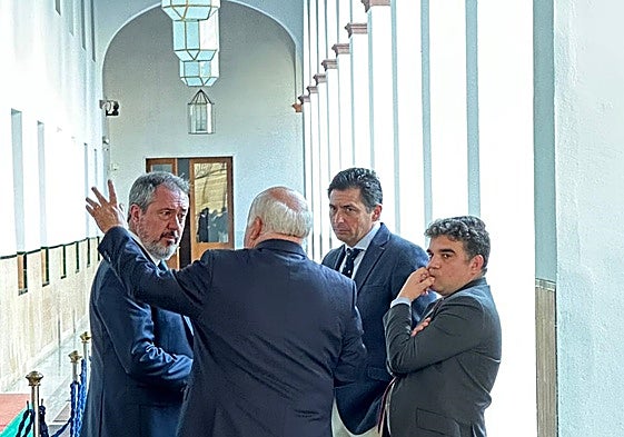 Aguirre (de espaldas) conversa con el presidente del Grupo Socialista, Juan Espadas.