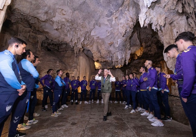 La plantilla del Málaga escucha atentamente al guía de la Cueva de Nerja.