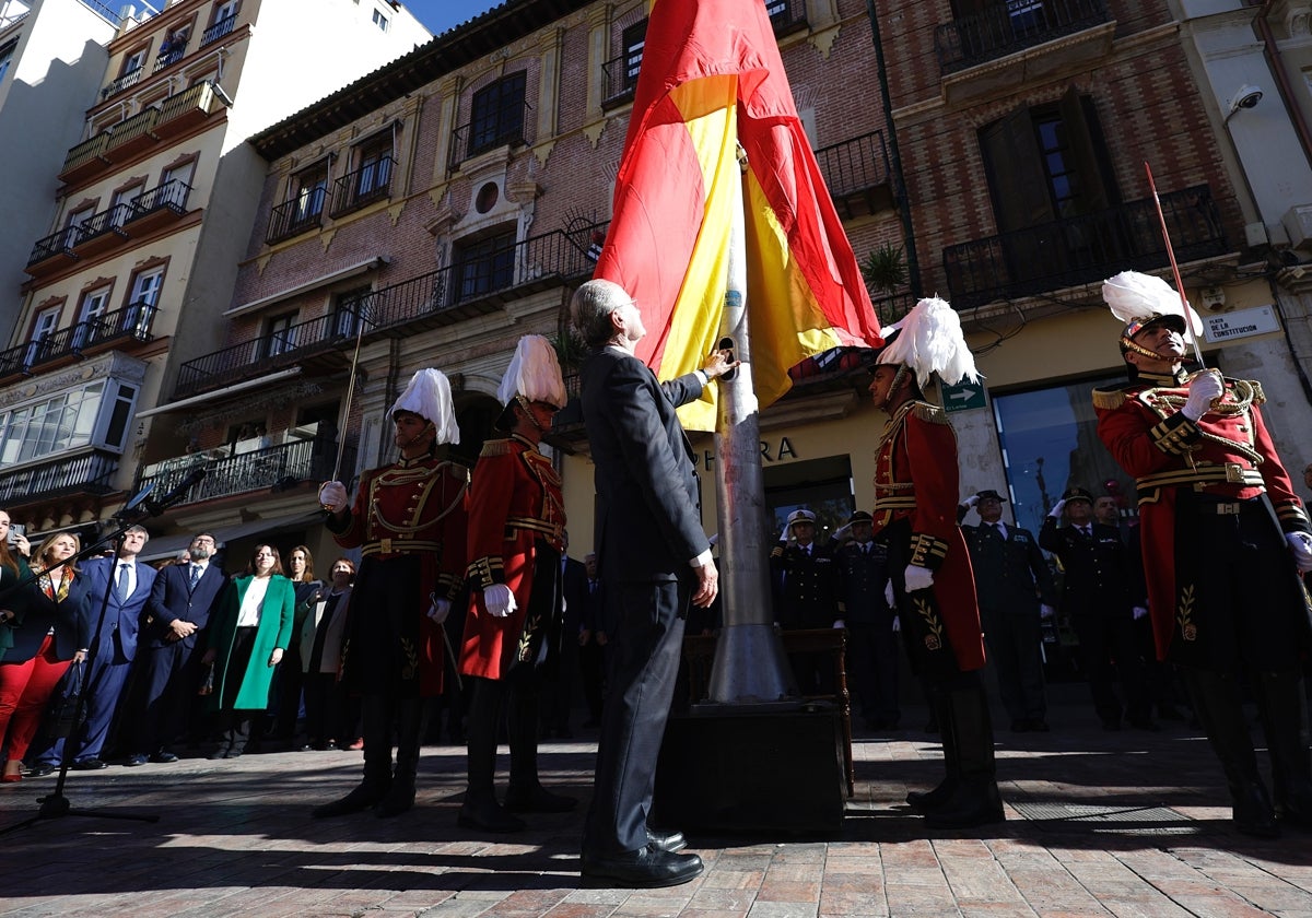 La imagen muestra el izado de la bandera durante el acto para conmemorar la Constitución.