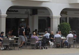 Clientes son atendidos en la terraza de un bar.