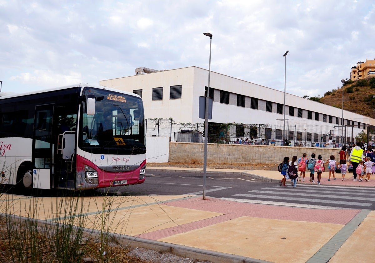 Niños cruzan la calle para ir al colegio tras bajar del bus.