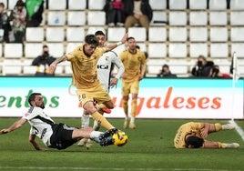 Antoñito intenta esquivar la entrada del jugador del Burgos, con Julen Lobete tendido en el suelo.