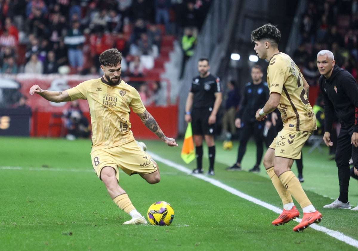 Dani Sánchez se dispone a golpear el balón en presencia de Antoñito, en el partido de El Molinón.