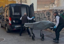 Empleados de la funeraria judicial retiran el cadáver de la víctima.