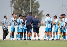 El juvenil División de Honor recibe instrucciones de su entrenador durante una pausa de hidratación.