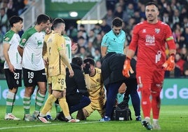 El responsable médico del Málaga atiende a Puga tras un fuerte golpe en la cabeza con Castro en el segundo tiempo del duelo de anoche.