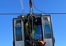 Bomberos en el interior de una de las cabinas del teleférico.