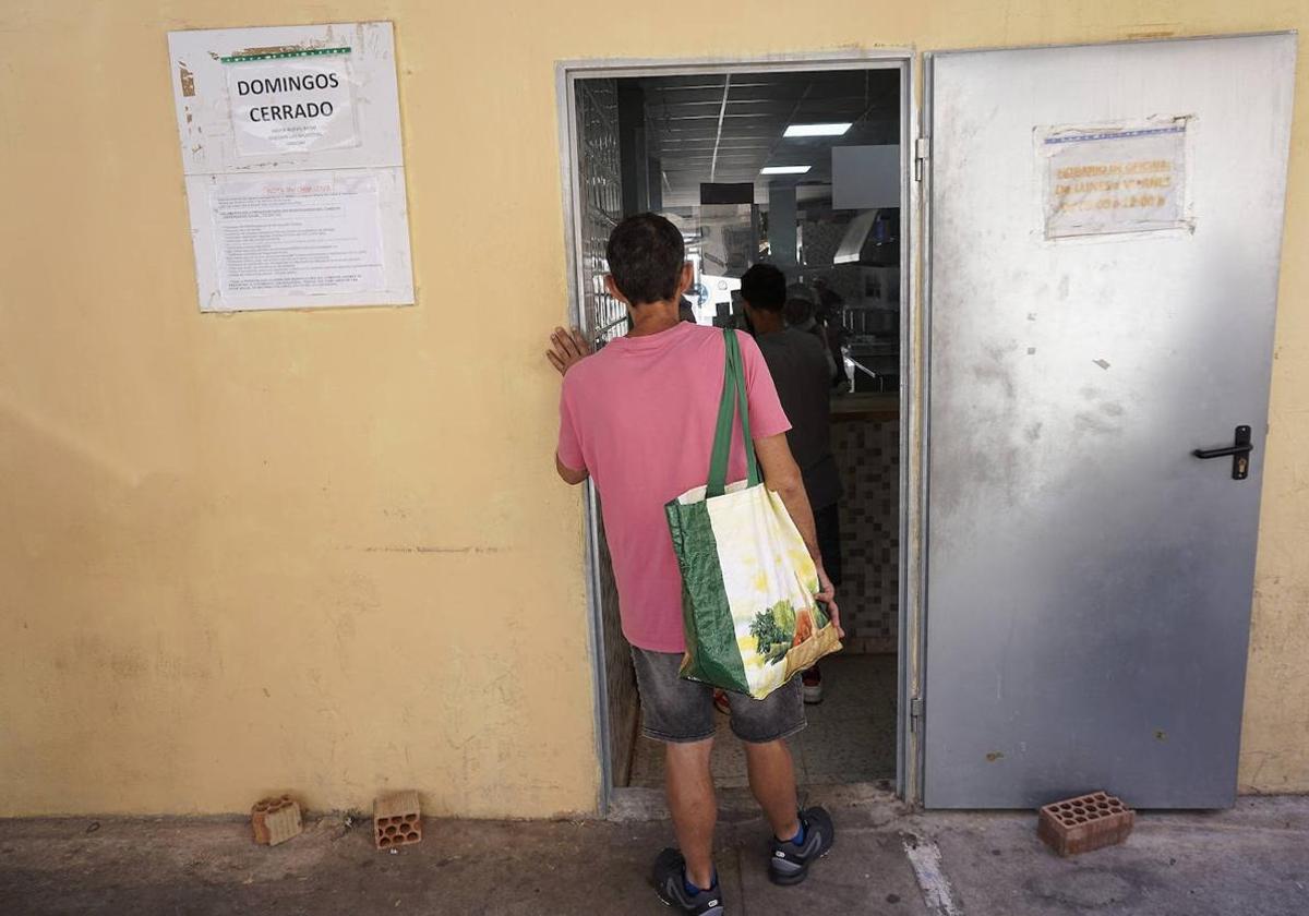 Una persona a la puerta de un comedor social.