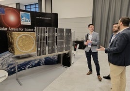 Participantes comentan uno de los expositores en el congreso de satélites de Málaga.