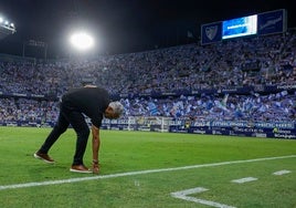 Pellicer se agacha para tocar el césped de La Rosaleda en el partido frente al Albacete.