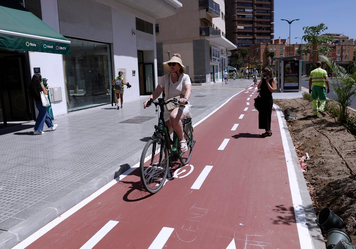 Una mujer monta en bicicleta en la renovada zona de Callejones del Perchel.