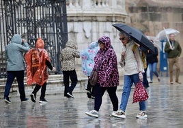 Turistas pasean por el Centro de Málaga bajo la lluvia, este miércoles.