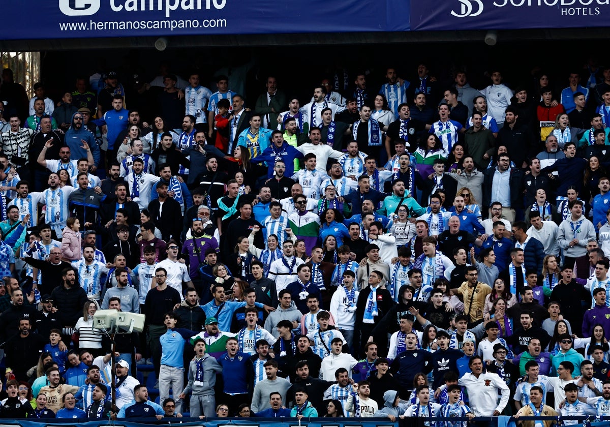 Aficionados del Málaga animan al equipo blanquiazul en La Rosaleda durante el partido frente al Almería.