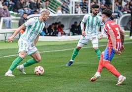 Samuele Longo se perfila para centrar delante del defensa del Atlético de Madrid B.