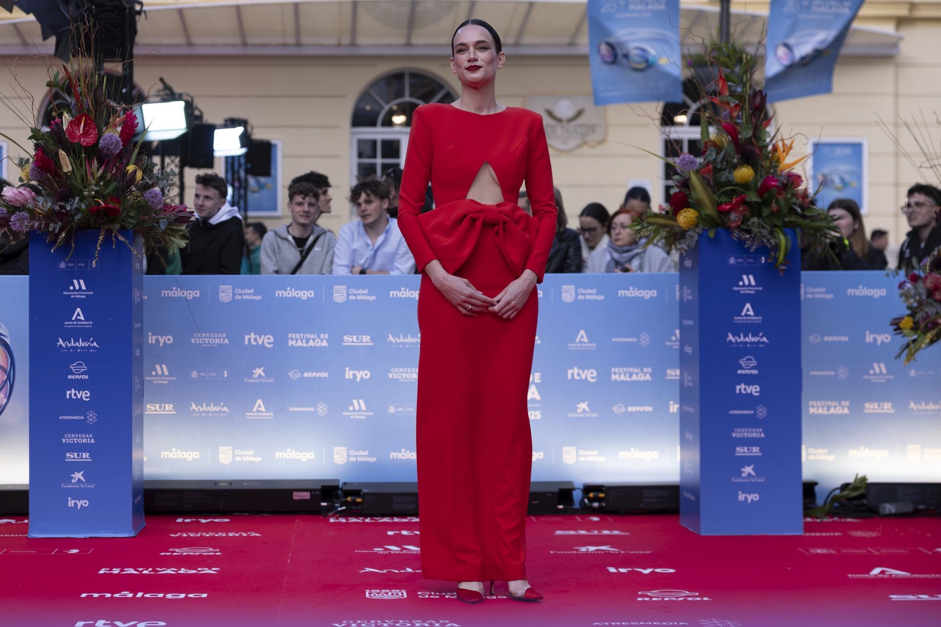 Iria Parada, con un original traje rojo con maxi lazada de Rubén Hernández, pasó examen con nota a las puertas del Teatro Cervantes. ¡Muy guapa!