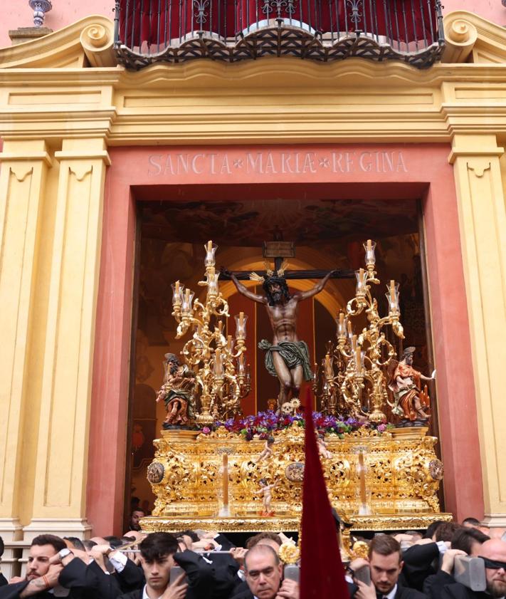 Imagen secundaria 2 - 1. Miembros de la cofradía del Rescate limpian un estandarte tras la lluvia caída. 2. Espectadores en las sillas con paraguas. El Cristo de la Agonía (Penas) tuvo que recogerse nada más salir. 