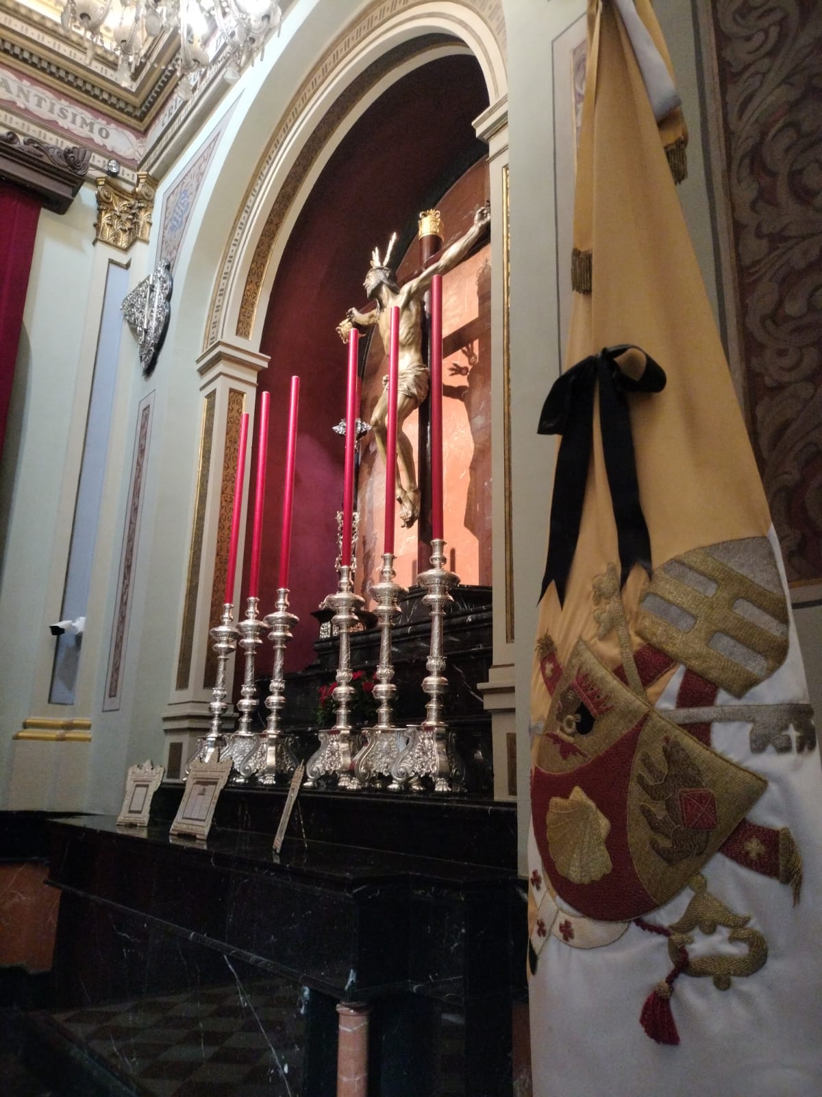 La bandera pontificia con un crespón negro junto al Cristo de la Expiración.