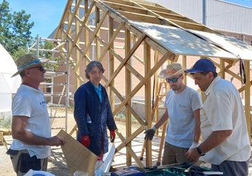 Esteban Guillén (primero por la izquierda) y Miguel Cardona (derecha), en su antiguo instituto, el IES La Rosaleda, para el que han colaborado en la instalación de pérgolas de madera.