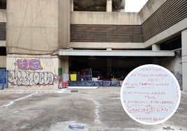 La imagen muestra el edificio de Correos y el cartel que han puesto los okupas en una de las entradas.
