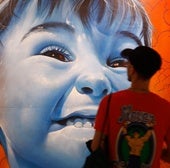 Lalone firma uno de los 21 murales hechos expresamente para la exposición.