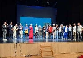 Foto de familia con los premiados y los dirigentes socialistas, en el escenario del teatro de Torrox.