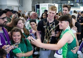 Alberto Díaz, trofeo en mano, se fotografía con unos aficionados en el aeropuerto.