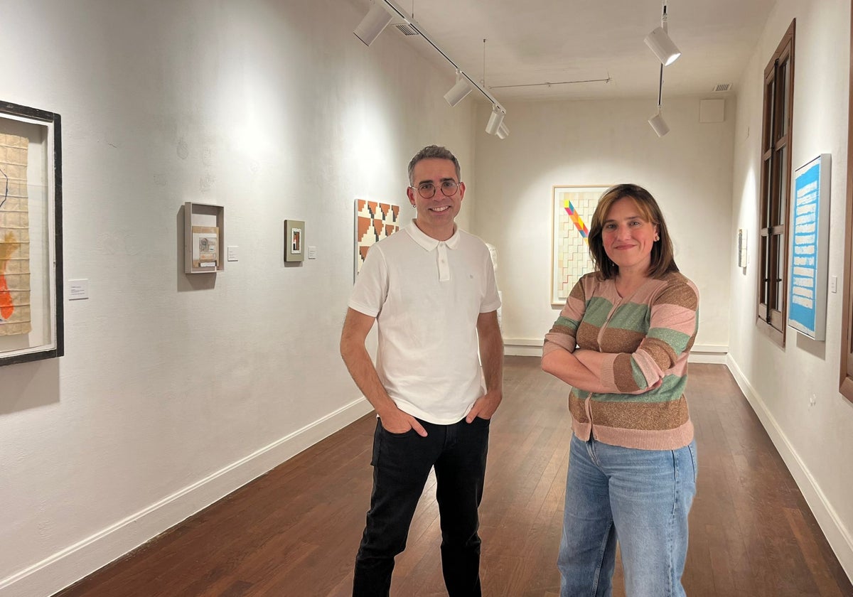Ester Ramos y Sergio Croma pasan junto a la exposición.