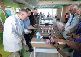 La consejera de Salud, a la derecha, juega al futbolín con varios sanitarios y con el delegado del ramo, Carlos Bautista.